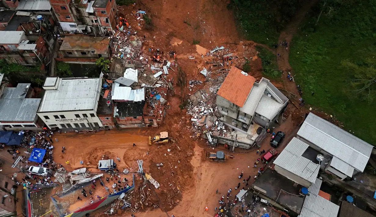 Tanah longsor telah menimbun sejumlah rumah warga dan menyebabkan kerusakan infrastruktur yang signifikan. Tampak foto udara menunjukkan tim penyelamat mencari korban di tengah reruntuhan setelah tanah longsor akibat hujan lebat di lingkungan Barrio Parque Jardim Burnier, Juiz de Fora, Negara Bagian Minas Gerais, Brasil, pada 24 Februari 2026. (Pablo PORCIUNCULA/AFP)