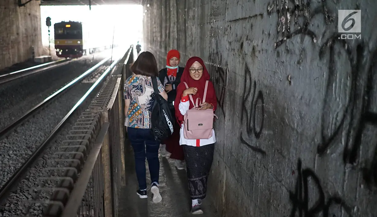 Pejalan kaki melintasi jalan setapak di sekitar Stasiun Cawang, Jakarta, Kamis (9/5). Meskipun sempit, jalan setapak tersebut masih menjadi pilihan sebagian pejalan kaki untuk menyeberangi Jalan Gatot Soebroto, dibanding harus melewati JPO yang jaraknya lebih jauh. (Liputan6.com/Immanuel Antonius)