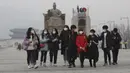 Para siswa mengenakan masker berjalan di Gwanghwamun Plaza di Seoul, Korea Selatan (10/12/2019). Kementerian Lingkungan Hidup Korsel menegakkan serangkaian tindakan darurat untuk mengurangi polusi debu halus, termasuk melarang kendaraan tertentu dari jalan pusat kota. (AP Photo/Ahn Young-joon)