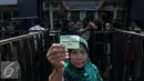 Warga menunjukan kupon Paket  Sembako Murah oleh PT Indosiar Visual Mandiri, di Studio 5 Indosiar, Jakarta, Jumat (10/6). Pembagian  Sembako Murah ini hanya di sekitaran wilayah kerja perusahaan PT Indosiar di Jalan Daan Mogot. (Liputan6.com/Johan Tallo)