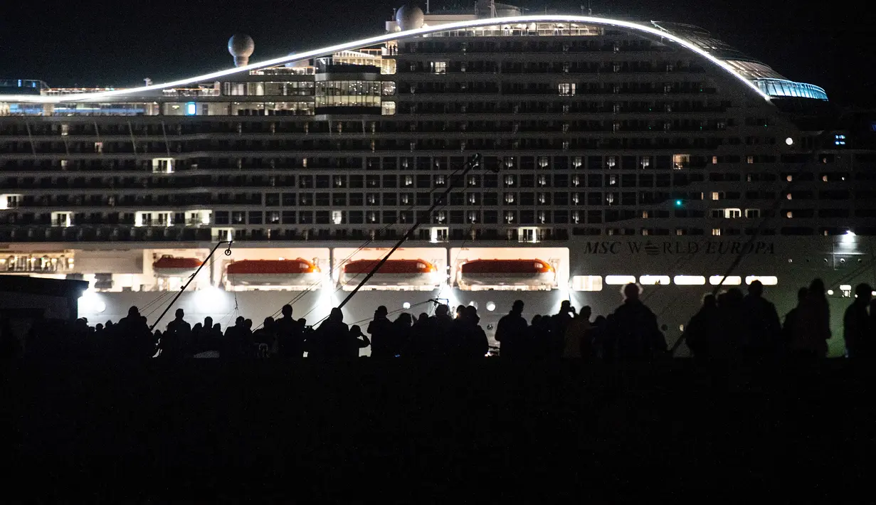 Warga menyaksikan kapal pesiar MSC World Europa meninggalkan pelabuhan Saint-Nazaire, Prancis barat pada 26 Oktober 2022.  MSC World Europa berlayar ke Qatar, di mana ia akan berfungsi sebagai hotel terapung selama Piala Dunia FIFA Qatar 2022. (AFP/Sebastien Salom Gomis)