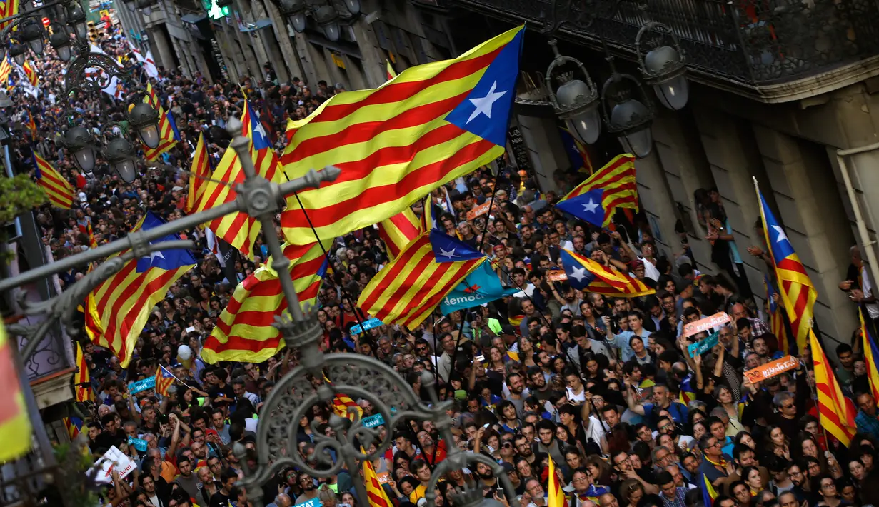 Para pendukung pro-kemerdekaan berkumpul di luar Gedung Palau Generalitat, Barcelona, Jumat (27/10). Parlemen regional Catalonia mendeklarasikan kemerdekaan dari Spanyol melalui pemungutan suara. (AP/Emilio Morenatti)