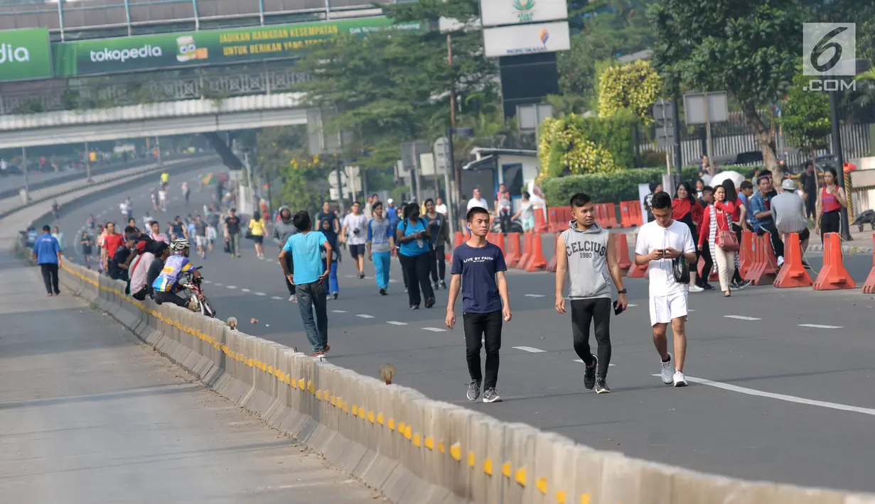 Warga berjalan santai di Jalan Jenderal Sudirman saat pelaksanaan Hari Bebas Kendaraan Bermotor (HBKB), Jakarta, Minggu (3/6). Pemprov DKI Jakarta berencana meniadakan pelaksanaan HBKB pada 10, 17, dan 24 Juni 2018. (Liputan6.com/Helmi Fithriansyah)