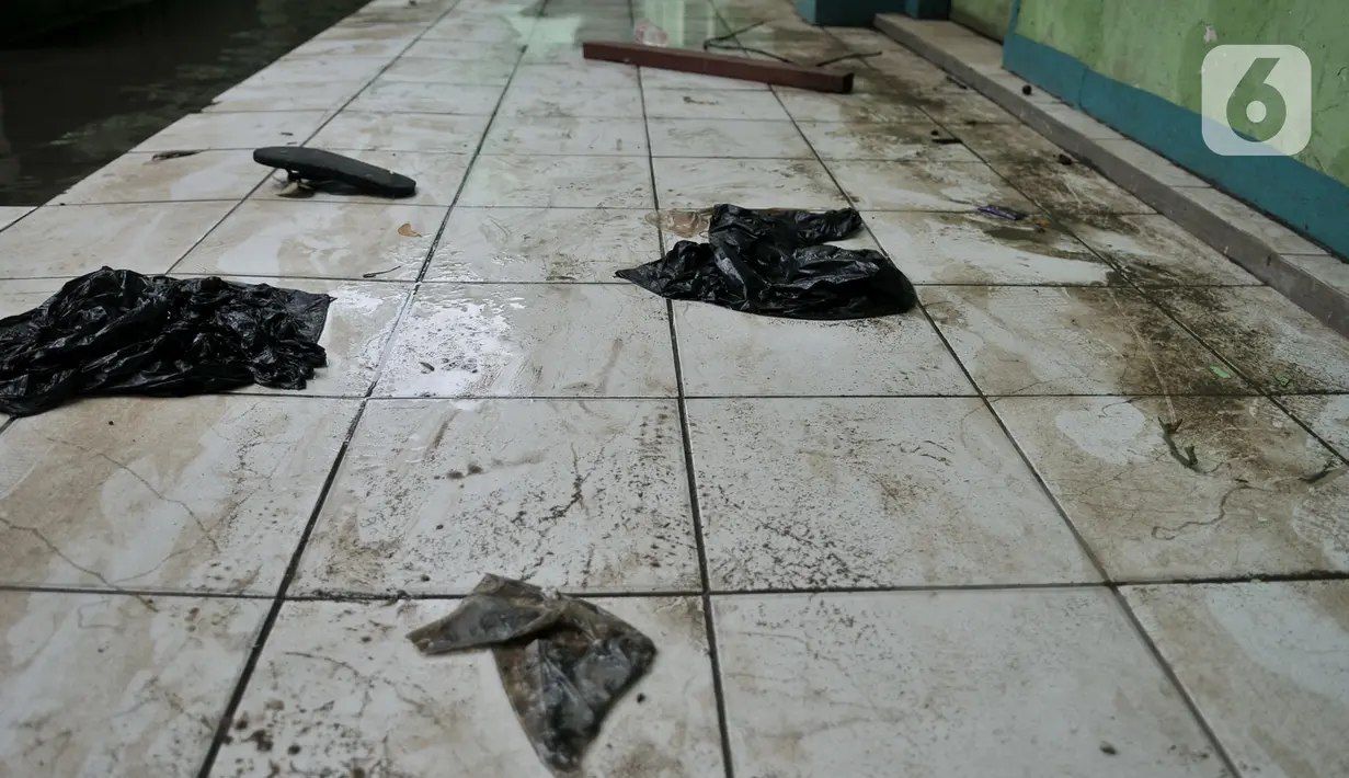 Sampah terlihat usai banjir menggenangi Madrasah Tsanawiyah (MTs) Nur Attaqwa, Pegangsaan Dua, Kelapa Gading, Jakarta Utara, Senin (24/2/2020). Banjir yang terjadi sejak Minggu (23/2) kemarin mengakibatkan kegiatan belajar di MTs itu terpaksa diliburkan sementara. (merdeka.com/Iqbal S Nugroho)