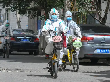 Perangkat masyarakat mengantarkan barang di permukiman Xihebaqianjie di Urumqi, Daerah Otonom Uighur Xinjiang, China, 3 Agustus 2020. Menggunakan sepeda sederhana dan sepeda listrik, sebuah tim layanan mengantarkan barang kebutuhan sehari-hari serta obat-obatan bagi warga. (Xinhua/Zhao Ge)