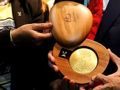 Komite dan Presiden Olimpiade Internasional (IOC) menunjukkan medali emas saat peluncuran medali Olimpiade 2016 Rio de Janeiro, Brasil (14/6). (REUTERS/ Sergio Moraes)