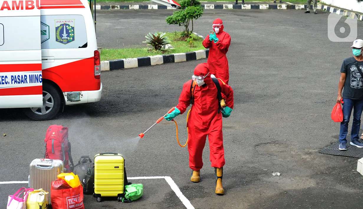 Petugas menyemprotkan disinfektan barang-barang pasien OTG Covid-19 di Graha Wisata Ragunan, Jakarta, (21/12/2020). Kepala Dinas Kesehatan DKI Jakarta Widyastuti menjelaskan prosedur isolasi mandiri bagi pasien Covid-19 diawali dengan proses asesmen dari petugas puskesmas. (merdeka.com/Arie Basuki)