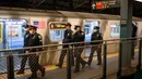 Polisi terlihat saat gerbong kereta bawah tanah dibersihkan dengan disinfektan di stasiun Coney Island di Brooklyn, Rabu (6/5/2020). Untuk pertama kalinya, sistem kereta bawah tanah New York dimatikan sementara agar dapat dibersihkan untuk menghentikan penyebaran virus corona. (COREY SIPKIN/AFP)