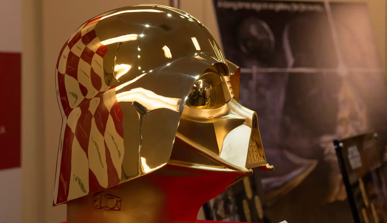Sebuah toko perhiasan di Jepang membuat topeng karakter Darth Vader, salah satu tokoh jahat di film Star Wars, berlapis emas murni. Topeng tersebut akan dipamerkan hingga 6 Mei mendatang, Jepang, Selasa (25/4). (AFP Photo/Kazuhiro NOGI)