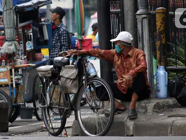 Pengojek sepeda menunggu penumpang di kawasan Kota Tua, Jakarta, Selasa (21/4/2020). Penghentian sementara aktivitas sebagian besar pertokoan dan perkantoran seiring pelaksanaan WFH dan PSBB berimbas pada sulitnya pengojek sepeda mencari penumpang. (Liputan6.com/Helmi Fithriansyah)