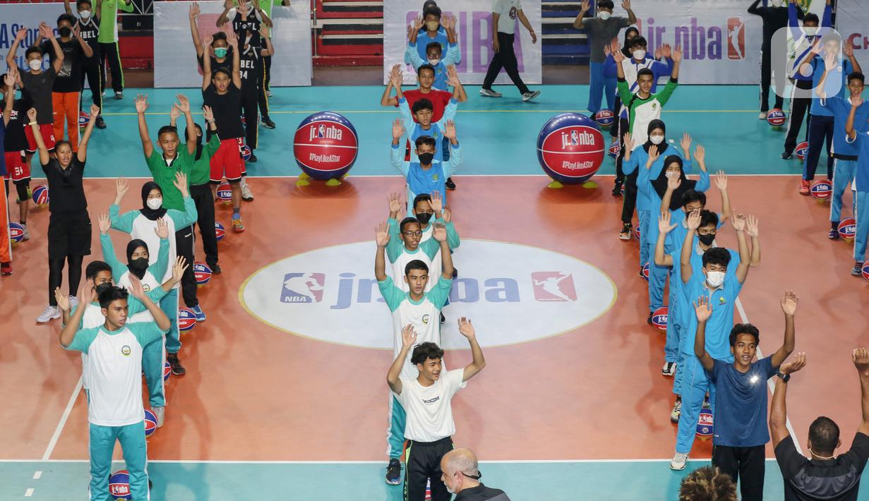 Siswa siswi Madrasah melakukan pemanasan sebelum mengikuti teknik dasar bola basket di GOR Bulungan Jakarta, Selasa (31/05/2022). Program Jr. NBA Coaches Academy yang dipimpin pelatih Jr. NBA Carlos Barroca dan Natalia Andrei Dos Santos telah mengedukasi lebih dari 53.000 guru di 46.000 sekolah, 25 kota dan provinsi di seluruh Indonesia. (Liputan6.com/Fery Pradolo)