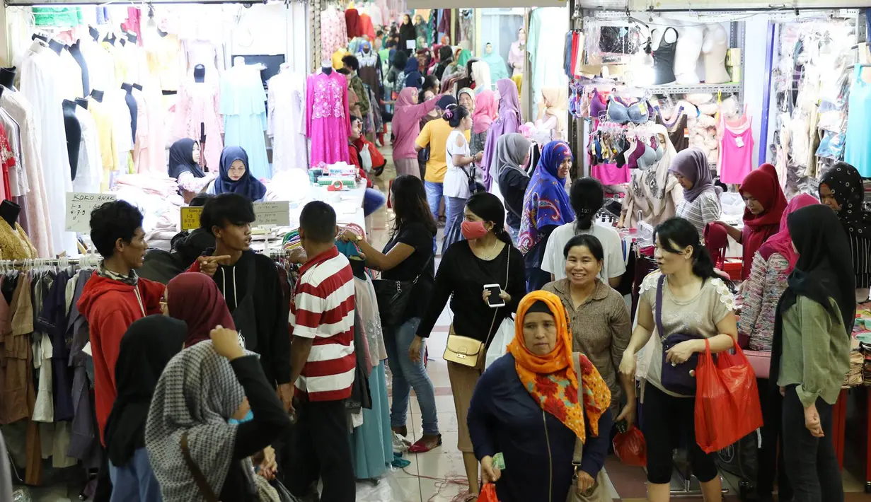 Pengunjung memadati Pasar Tanah Abang, Jakarta, Minggu (18/6). Jelang Lebaran, pusat tekstil tersebut dipenuhi pengunjung yang mencari busana muslim untuk hari raya. (Liputan6.com/Immanuel Antonius)