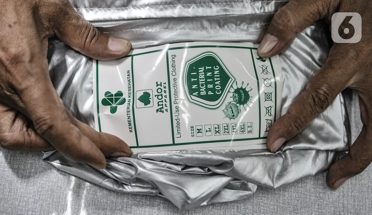 Pekerja menempelkan stiker rekomendasi dari Kemenkes pada salah satu baju hazmat di salah satu industri konveksi Pusat Industri Kecil (PIK), Jakarta, Rabu (30/12/2020). Permintaan hazmat hingga kini masih tinggi seiring terus meningkatnya kasus COVID-19 di Indonesia. (merdeka.com/Iqbal S. Nugroho)