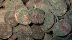 Kumpulan koin kuno Romawi yang diperlihatkan di museum arkeologi di Sevilla, Kamis (28/4). Koin kuno yang memiliki bobot total 600 kg itu ditemukan ketika para pekerja konstruksi  sedang mengerjakan proyek pipa air di Spanyol Selatan. (Gogo Lobato/AFP)