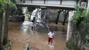 Seorang anak melintasi banjir yang menggenangi kawasan Cilandak Timur, Jakarta Selatan, Selasa (22/1). Hujan deras yang mengguyur Jakarta dan sekitarnya sejak pagi menyebabkan banjir di sejumlah sudut Ibu Kota. (Liputan6.com/Immanuel Antonius)