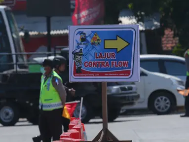 Papan penunjuk arah contra flow terpasang di jalur alteri Brebes Timur, Jawa Tengah, Senin (4/7). Petugas menambah jangkauan contra flow yang sebelumnya 10 km menjadi 12 km untuk mengurai kemacetan panjang di kawasan tersebut. (Liputan6.com/Angga Yuniar)