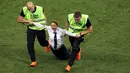 Petugas mengamankan seorang wanita yang menyusup masuk ke lapangan dalam laga final Piala Dunia 2018 antara Prancis dan Kroasia di Luzhniki Stadium, Minggu (15/7). Empat orang berlari masuk ke dalam lapangan menggangu jalannya laga. (AP/Martin Meissner)