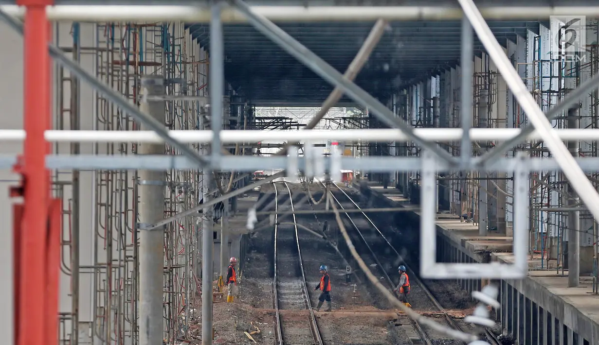 Pekerja menyelesaikan pembangunan proyek Stasiun Sudirman Baru di Jakarta, Minggu (23/7). Pyoyek tersebut merupakan salah satu dari 5 stasiun yang dibangun khusus untuk menunjang Kereta Bandara Soetta. (Liputan6.com/Immanuel Antonius)