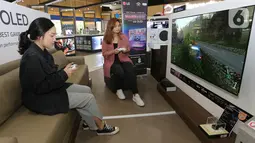 Pengunjung mencoba video game yang ditampilkan layar TV OLED LG di Jakarta, Rabu (12/2021). TV OLED C1 didesain dengan memiliki fitur Game Optimizer memudahkan pengguna mengoptimalkan berbagai pengaturan sesuai kebutuhan gaming. (Liputan6.com)