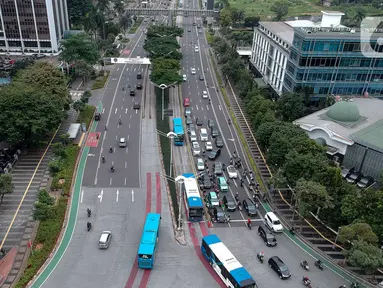 Foto aerial kendaraan melintas di Jalan Jenderal Sudirman, Jakarta, Selasa (24/3/2020). Sejumlah ruas jalan utama ibu kota lebih lengang dibandingkan hari biasa karena sebagian perusahaan telah menerapkan bekerja dari rumah guna menekan penyebaran COVID-19. (Liputan6.com/Faizal Fanani)