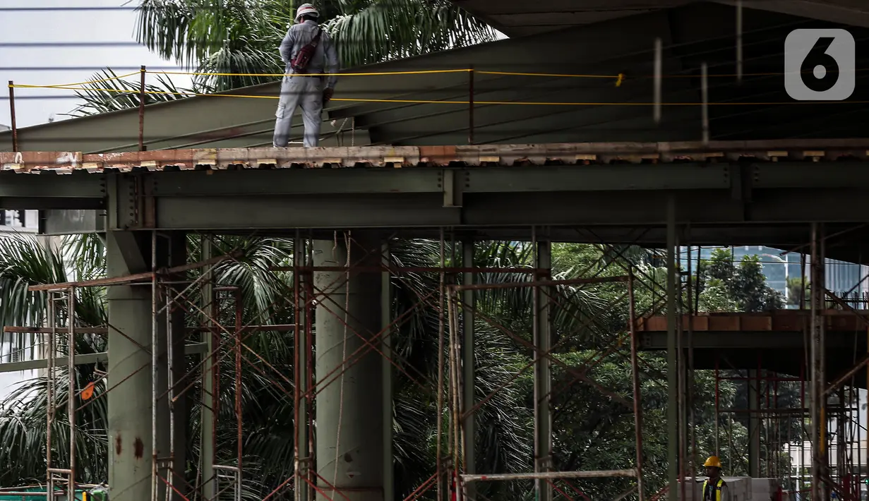 Pekerja menyelesaikan proyek pembangunan Jembatan layang (skybridge) CSW di Jakarta, Selasa (9/3/2021). Proyek pembangunan jembatan layang atau skybridge untuk integrasi Halte Transjakarta CSW di Stasiun MRT Asean ditargetkan selesai pada Mei 2021. (Liputan6.com/Johan Tallo)