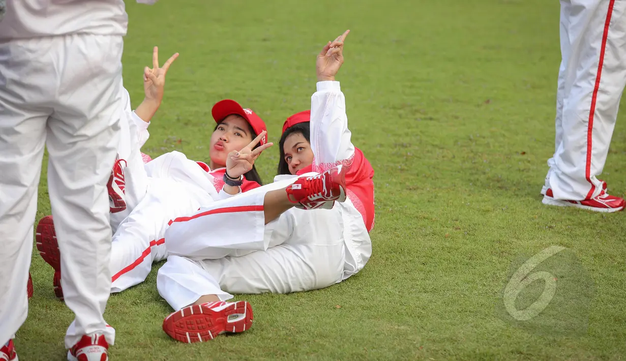 Dua orang atlet berselfie di rumput depan Istana Merdeka, Jakarta, Selasa (26/5/2015). Indonesia menurunkan 522 atlet yang berlaga di 32 cabang olah raga. (Liputan6.com/Faizal Fanani)