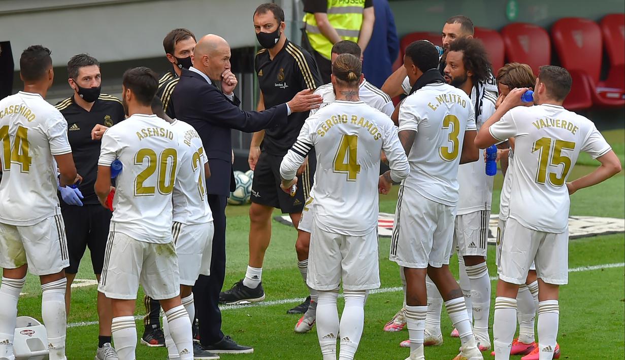 Pelatih Real Madrid, Zinedine Zidane, memberikan arahan kepada anak asuhnya saat melawan Athletic Bilbao pada laga La liga di Stadion San Mames, Minggu (5/7/2020). Real Madrid menang 1-0 atas Athletic Bilbao. (AFP/Ander Gillenea)