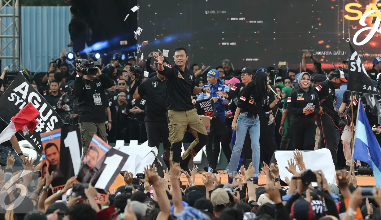 Calon Gubernur DKI Jakarta no 1 Agus Yudhoyono membagikan atribut saat Kampanye Akbar Satukan Jakarta di kawasan Kuningan, Jakarta, Sabtu (11/02). (Liputan6.com/Herman Zakharia)