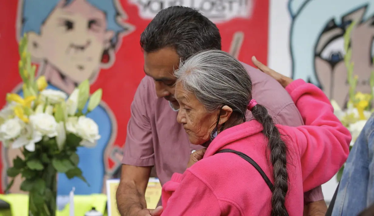 Orang-orang saling berpelukan dalam peringatan mengenang korban overdosis di Vancouver, British Columbia, Kanada (31/8/2020). Acara ini untuk meningkatkan kesadaran akan overdosis dan mengurangi stigma terhadap kematian terkait narkoba. (Xinhua/Liang Sen)
