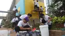 Sejumlah siswa menyiapkan cat untuk membuat mural di bawah kolong jalan layang non tol Kasablangka, Jakarta, Jumat (1/12). Mural tersebut di lakukan untuk mempercantik kawasan tersebut. (Liputan6.com/Angga Yuniar)