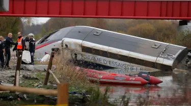 Petugas saat melakukan evakuasi terhadapa kereta yang tergelincir dan jatuh disebuah sungai dekat Strasbourg, Perancis, Sabtu (14/11/2015). Diduga kereta tergelincir karena menggunakan kecepatan yang berlebihan. (REUTERS/Vincent Kessler)