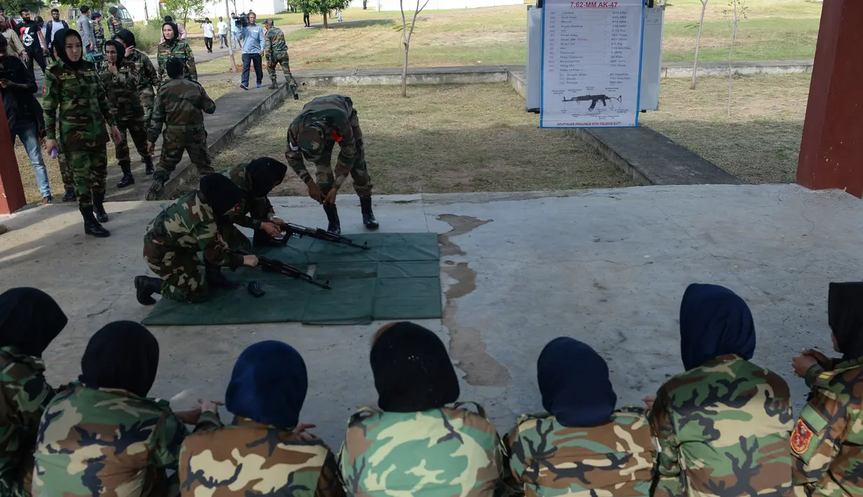 Sejumlah kadet tentara wanita Afghanistan memperhatikan pengarahan pelatih yang mengajarkan cara menyiapkan senapan sebelum menembak saat mengikuti program latihan militer di Akademi Pelatihan Perwira di Chennai, India (12/12/2019). (AFP/Arun Sankar)
