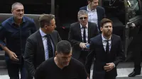 Bintang Barcelona, Lionel Messi (kanan) dan ayahnya, Jorge Horacio Messi mendapat pengawalan ketat saat menuju pengadilan di Kantor Pengadilan Barcelona, (2/6/2016). (AFP/Josep Lago)