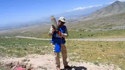 Seorang penjinak ranjau Afghanistan dari Halo Trust bersiap meledakkan ranjau yang belum meledak (UXO) di sebuah bukit di distrik Deh Sabz, Kabul pada tanggal 21 Mei 2024. (Wakil KOHSAR/AFP)