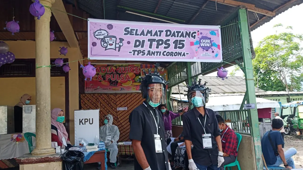 Tempat pemungutan suara (TPS) 15 Limau Manis Selatan, Kecamatan Pauh, Kota Padang Sumatera Barat pada Pilkada serentak 9 Desember 2020, petugas di lokasi itu mengenakan helm berbentuk virus corona sambil melayani para pemilih yang datang.