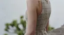 Margaret Qualley tampil effortlessly chic dalam balutan mini dress berbahan tweed khas Chanel. Gaun tanpa lengan dengan motif kotak-kotak halus itu dipadukan dengan sepasang sepatu two-tone putih dan hitam, memberi kesan klasik namun segar.  [Dok/Chanel].