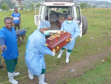 Petugas yang mengenakan pakaian pelindung menurunkan peti mati berisi jenazah balita berusia 3 tahun yang meninggal akibat Ebola saat pemakaman di Bunia, Provinsi Ituri, Kongo timur, Selasa, 18 Agustus 2026. (Foto AP/Dieudonne Dirole)