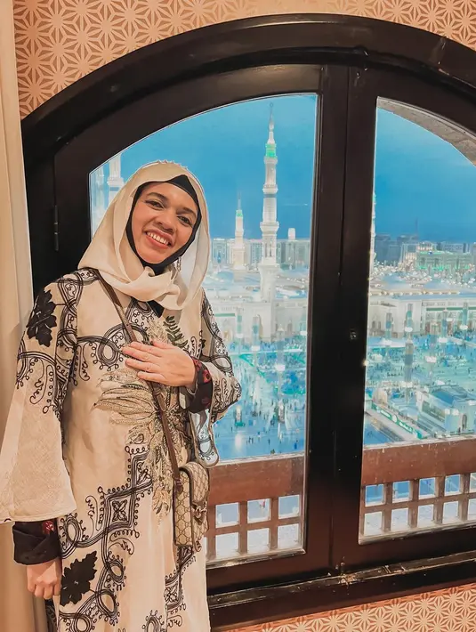 Istri Halilintar Anofial Asmid ini kerap tampil dengan model hijab ala anak muda. Pilihan hijabnya selalu mengikuti tren gaya hijab kekinian yang senada dengan warna baju dengan motif nuansa alam yang dikenakannya saat berada di Tanah Suci Makkah. (Liputan6.com/IG/@genifaruk).