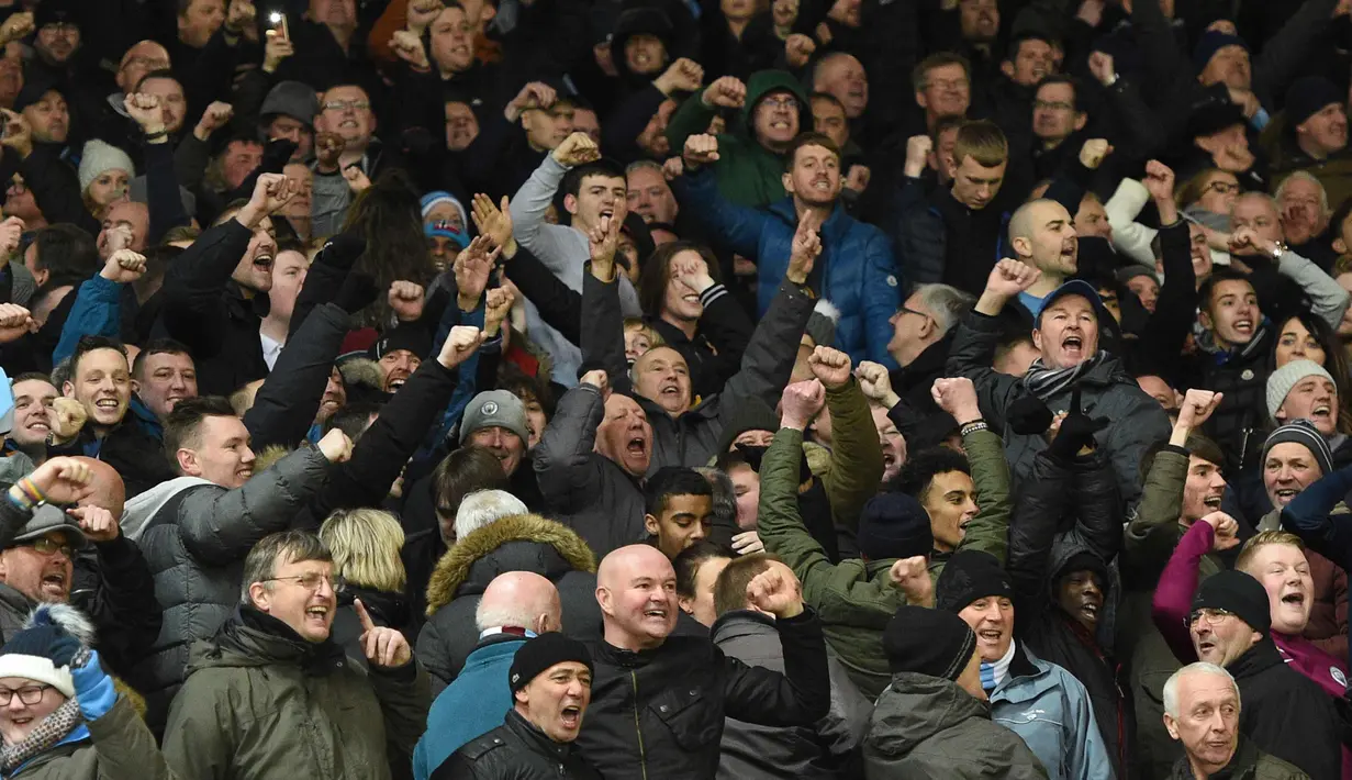 Para suporter Manchester City bersorak merayakan kemenangan tim kesayangannya menang atas Manchester United pada Liga Inggris di Old Trafford Stadium, Inggris, (10/12). City menang atas MU 2-1. (AFP Photo/Oli Scarff)