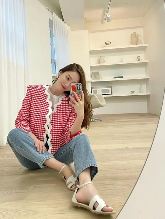 Preppy look memang tidak lengkap tanpa blazer. Di sini, Jessica Jung tampil kasual yang manis dengan blazer kotak-kotak merah putih, yang dipadunya dengan celana jeans dan sandal berwarna putih. Foto: Instagram @jessica.syj.