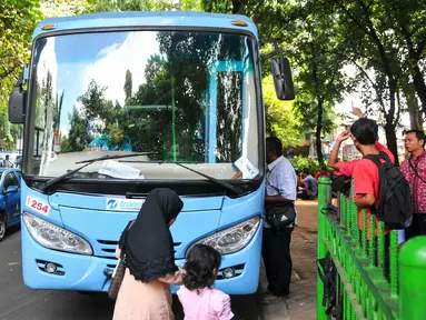 Penumpang saat akan menaiki feeder bus Transjakarta di Stasiun Tebet, Jakarta, Kamis (7/4). Armada itu dikerahkan untuk mengantisipasi penumpukan penumpang saat perlintasan KRL Tebet ditutup. (Liputan6.com/Yoppy Renato)