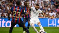 Penyerang Real Madrid, Karim Benzema, melakukan tendangan ke gawang Barcelona pada laga pekan kesembilan La Liga 2022/2023 di Santiago Bernabeu, Madird, Minggu (16/10/2022) malam WIB. (AFP/PIERRE-PHILIPPE MARCOU)