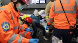 Sejumlah petugas medis mengevakuasi korban kebakaran di Stasiun Tsim Sha Tsui, Hong Kong (10/2). Akibat insiden ini, Stasiun Tsim Sha Tsui ditutup untuk sementara dan terdapat gangguan layanan di Jalur Tsuen Wan. (Handout / Apple Daily / AFP)