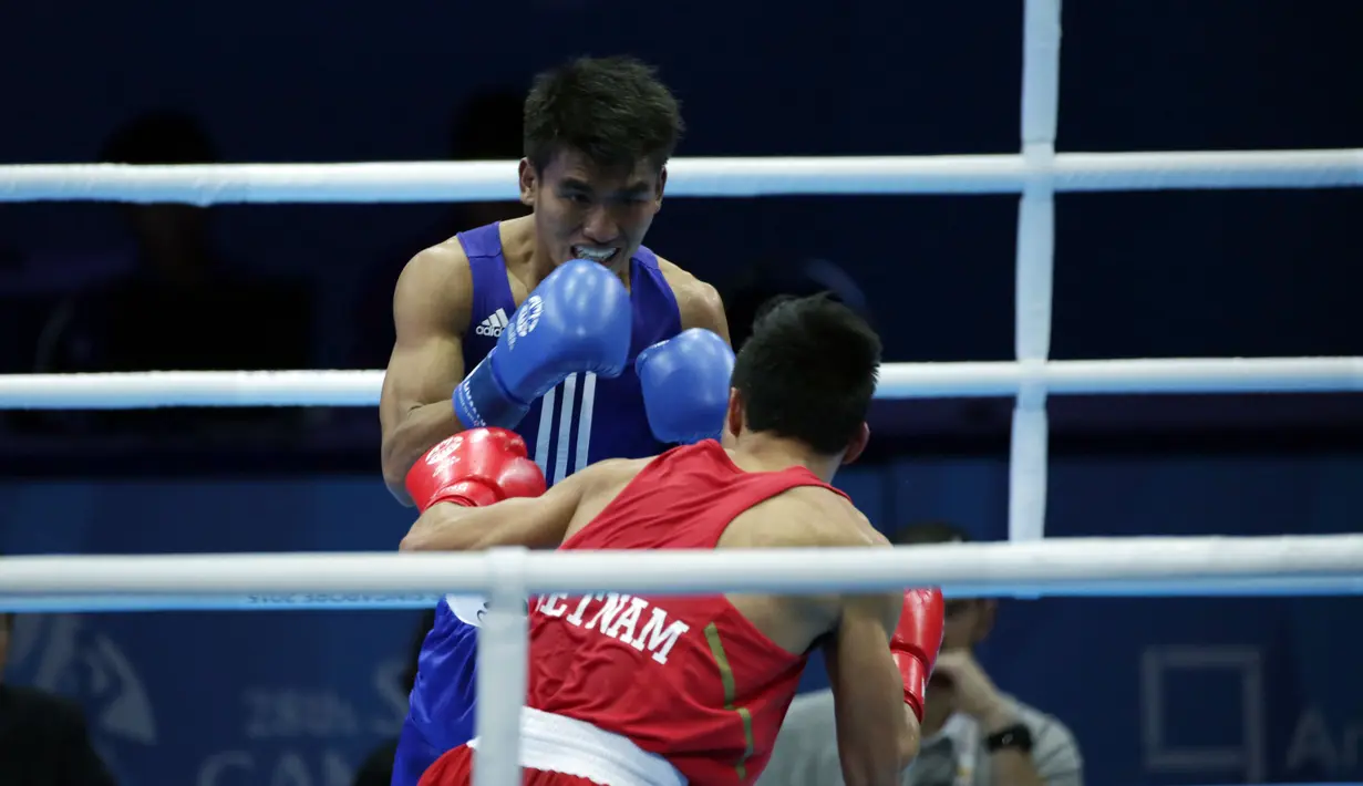 Petinju Indonesia, Farrand Papendang (kaus biru) dipaksa mengakui ketangguhan petinju Vietnam, Nguyen Van Hai di kelas 60 kg Sea Games yang berlangsung di SingaporeExpo, SIngapura, Senin (8/6/2015). (Liputan6.com/Helmi Fithriansyah)