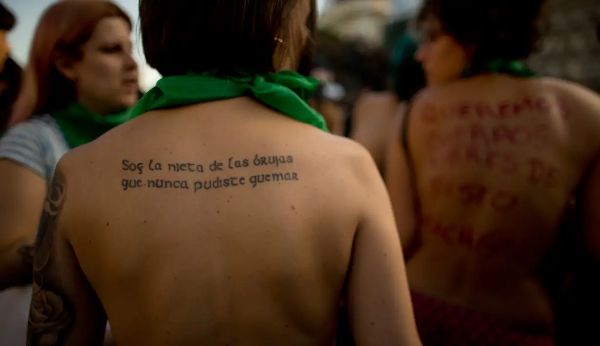Wanita dengan tulisan protes di punggungnya ikut dalam unjuk rasa telanjang dada di Buenos Aires, Argentina, Selasa (7/1). Mereka melakukan protes atas kekerasan yang dilakukan aparat kepolisian terhadap perempuan tanpa bra. (AP Photo/Natacha Pisarenko)
