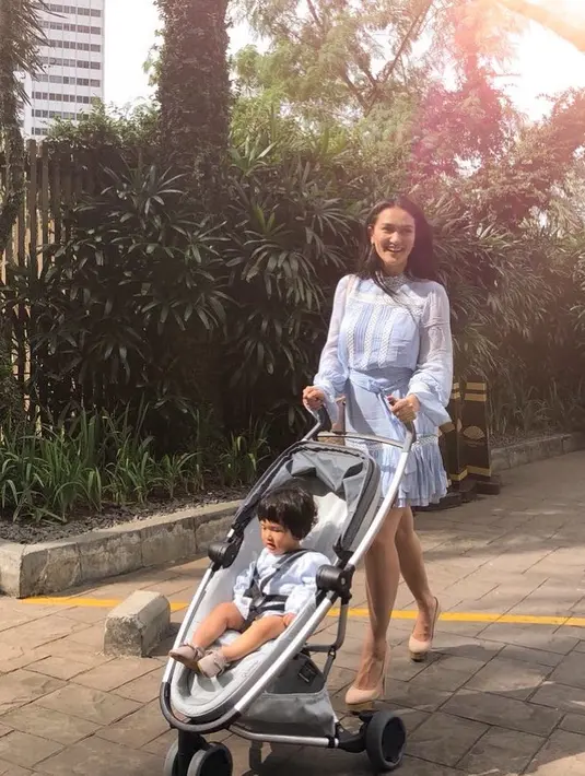 Sal dan Atiqah memang seringkali habiskan waktu bersama. Seperti yang satu ini, keduanya terlihat asik berjalan-jalan di taman dengan Sal duduk di stroller yang didorong oleh ibunya. (Instagram/atiqahasiholan)