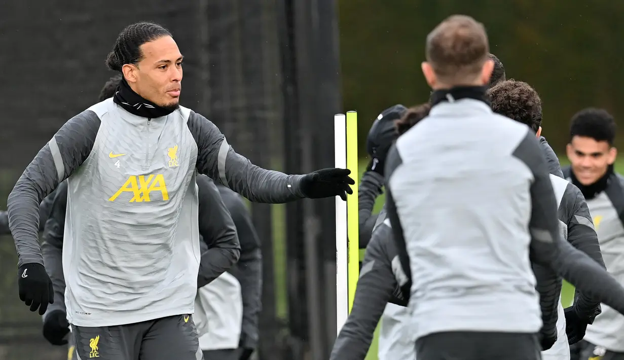 Bek Liverpool Virgil van Dijk (kiri) menghadiri sesi latihan di tempat latihan mereka di Kirkby, utara Liverpool, 15 Februari 2021. Liverpool akan melawat ke markas Inter Milan pada leg pertama babak 16 besar Liga Champions 2021/22, Kamis 17 Februari 2022. (Paul ELLIS / AFP)
