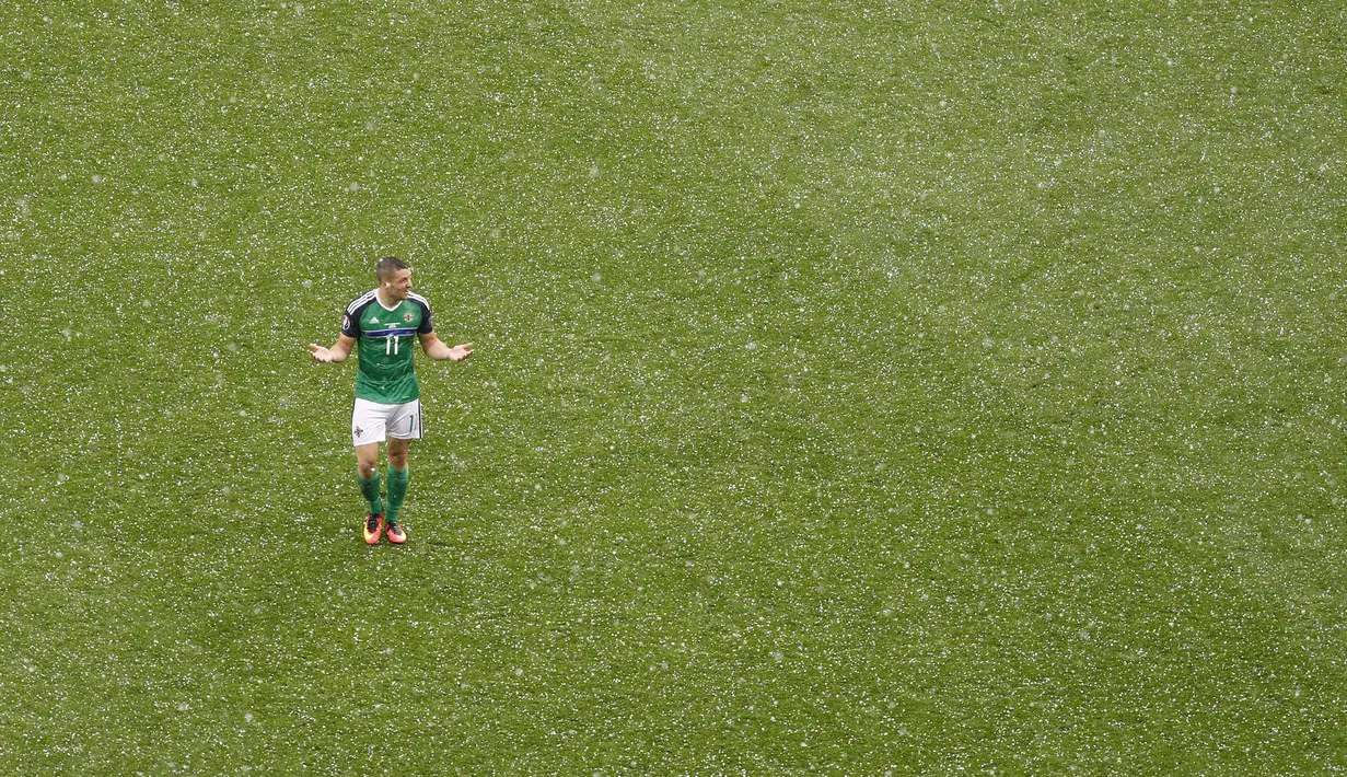  Pemain Irlandia Utara, Conor Washington berjalan ditengah derasnya hujan batu es saat melawan Ukraina pada laga grup C  Euro 2016 di Stadion Parc Olympique Lyonnais, Kamis ( 16/6/2016) WIB. (REUTERS/Max Rossi)