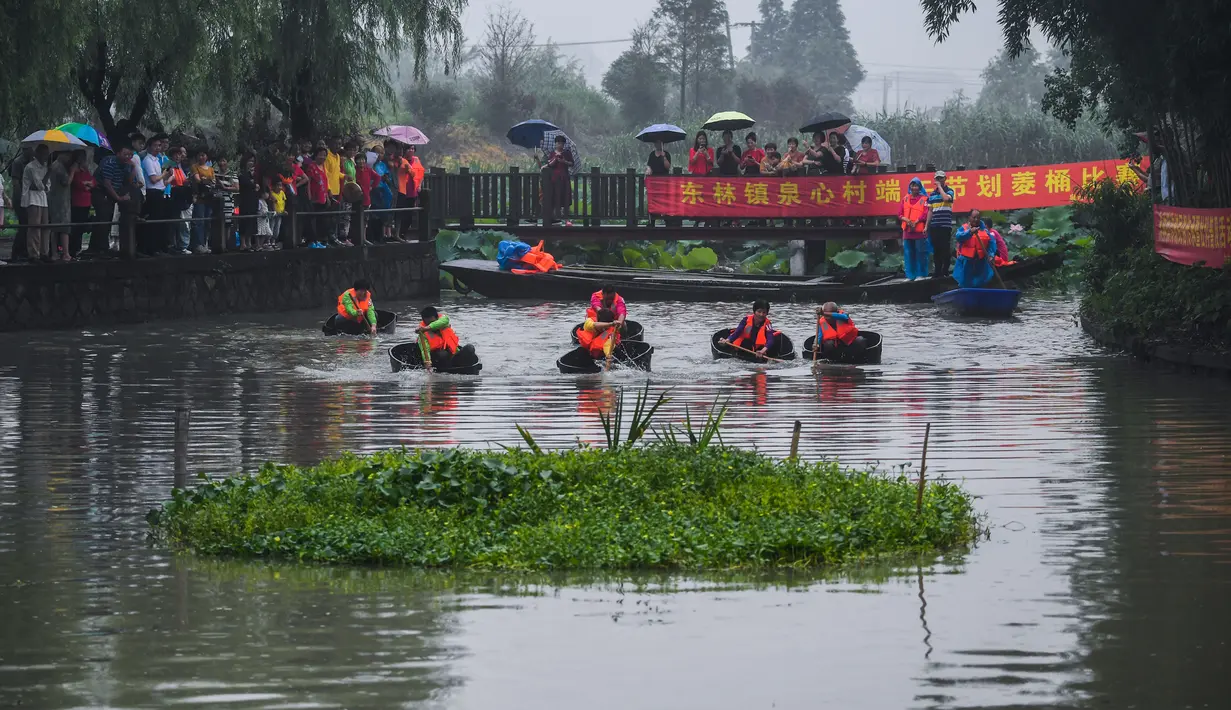 Warga desa berpartisipasi dalam kontes mendayung ember di Desa Quanxin, Kota Huzhou, Provinsi Zhejiang, China, Selasa (23/6/2020). Ember purun tikus (water chestnut) merupakan alat kerja tradisional yang dimiliki setiap rumah tangga di kota-kota perairan di China. (Xinhua/Xu Yu)