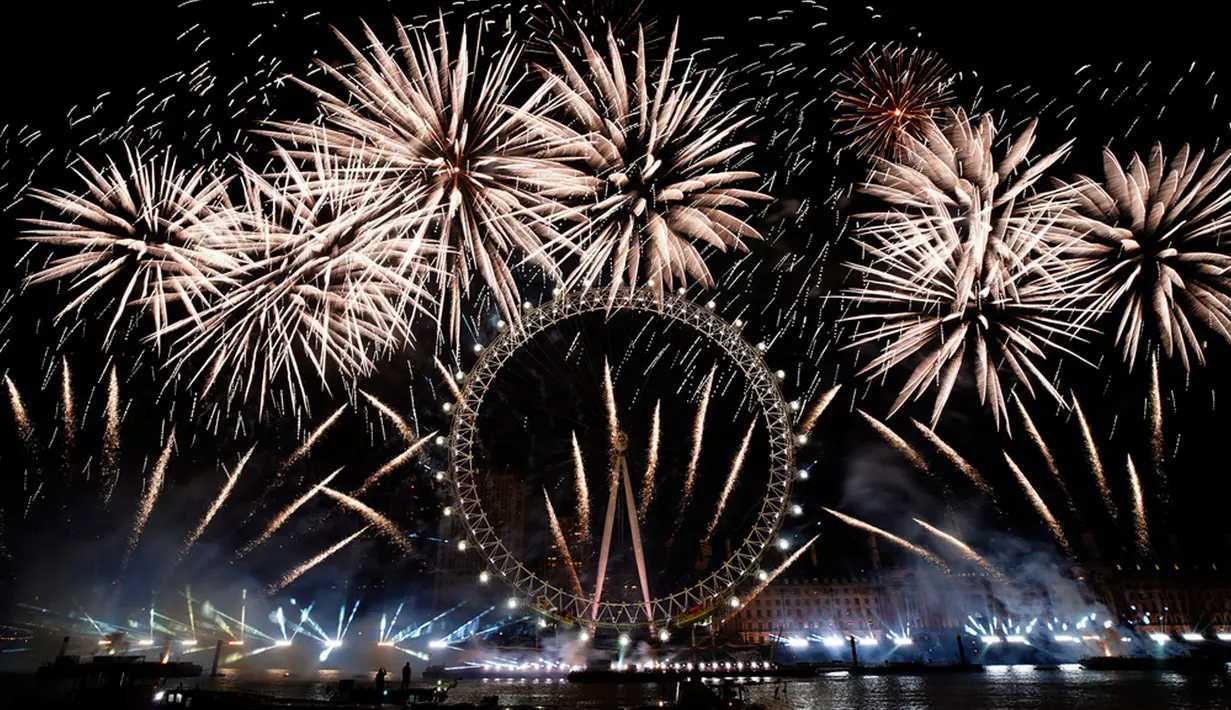 Kembang api menerangi langit di atas London Eye di pusat Kota London untuk merayakan Tahun Baru pada Senin (1/1/2024). (AP Photo/Alberto Pezzali)